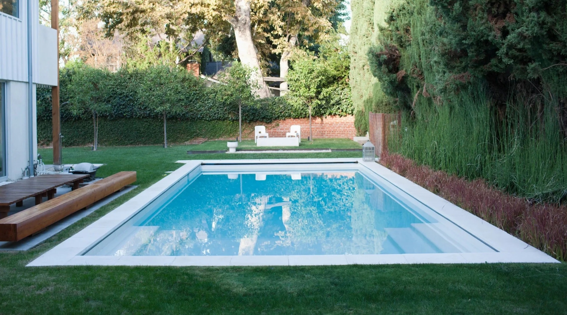 Friends enjoying a pool party in a landscaped backyard